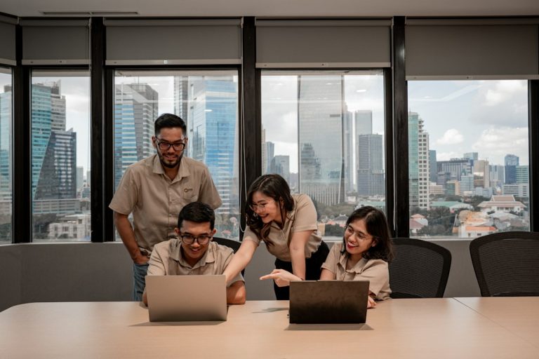 Singapore SME team working together on laptops in a city office